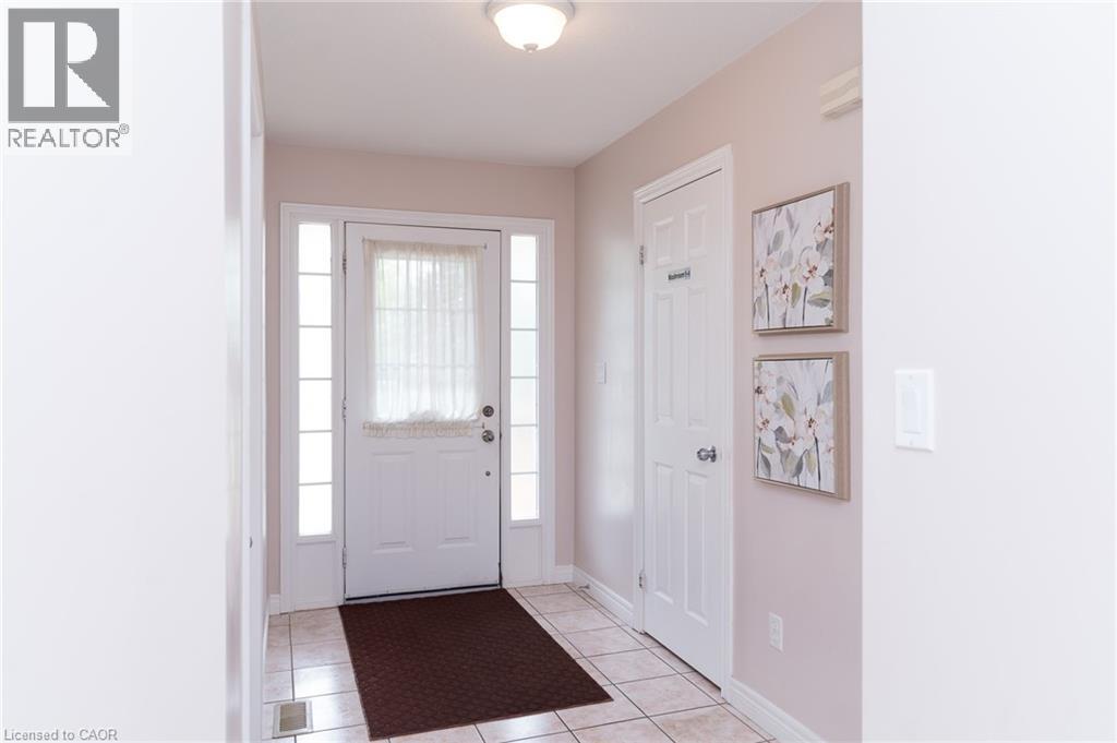 Entryway featuring light-toned walls, tile flooring, and a white paneled door with side lights - 566 Avignon Place, Waterloo, ON