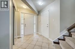 Entryway featuring a white paneled front door with sidelights, tile flooring, and a mirrored closet -