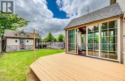 Expansive outdoor deck with a sunroom featuring multiple sliding glass doors -