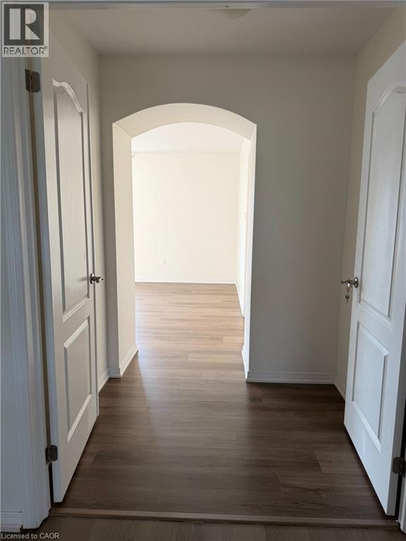 Inviting entryway featuring wood-finish flooring, an arched doorway, and light-colored walls - 235 Apple Hill Crescent, Kitchener, ON