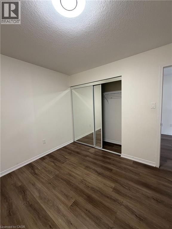 Interior room featuring wood-finish flooring, white walls, and white baseboards - 235 Apple Hill Crescent, Kitchener, ON