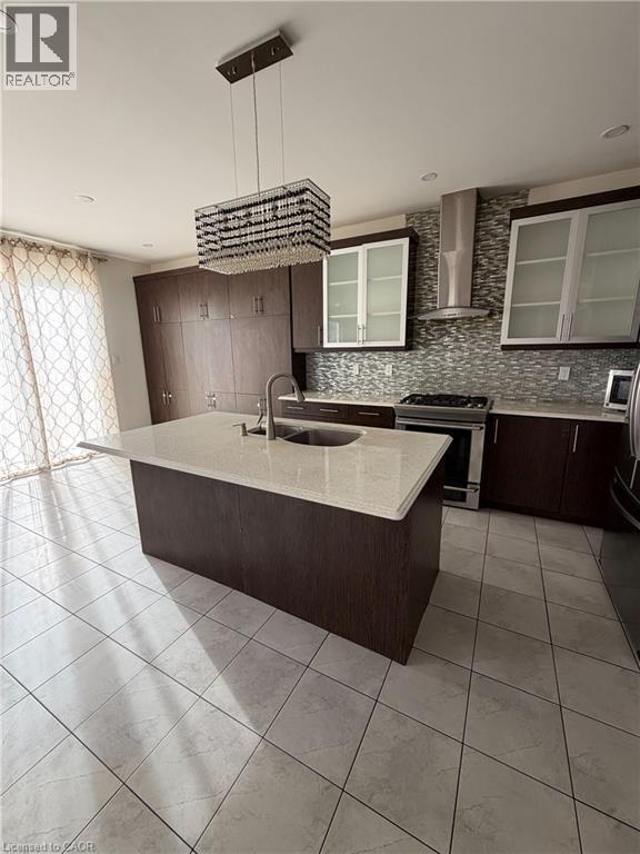 Kitchen featuring a central island with an undermount sink and light-toned countertop - 235 Apple Hill Crescent, Kitchener, ON