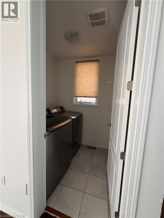 Laundry area featuring tile flooring, a window with blinds, and white walls - 235 Apple Hill Crescent, Kitchener, ON