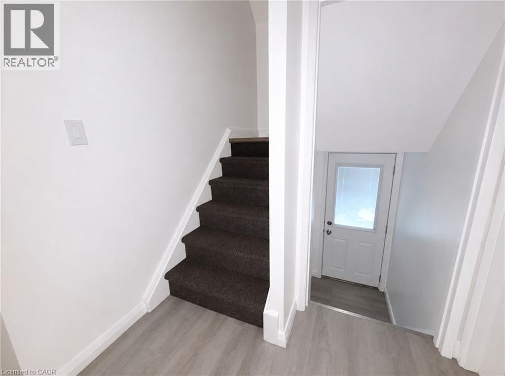 Carpeted staircase with white risers and white baseboards - 83 East 41St Street, Hamilton, ON - Indoor Photo Showing Other Room