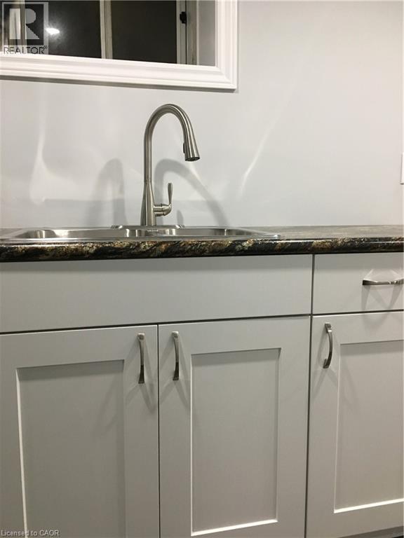 Kitchen sink featuring a dual basin, stainless steel faucet, and granite-finish countertop - 92 Pattandon Avenue Unit# C, Kitchener, ON - Indoor Photo Showing Kitchen