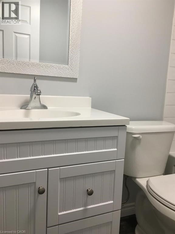 White beadboard vanity with a solid white countertop and integrated sink - 92 Pattandon Avenue Unit# C, Kitchener, ON - Indoor Photo Showing Bathroom