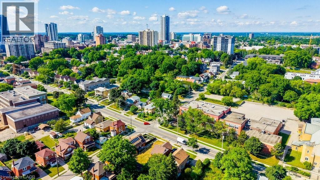 Aerial perspective showcasing a vibrant urban landscape with diverse architectural styles, a grid of residential streets, and abundant mature trees - 153 Courtland Avenue E, Kitchener, ON