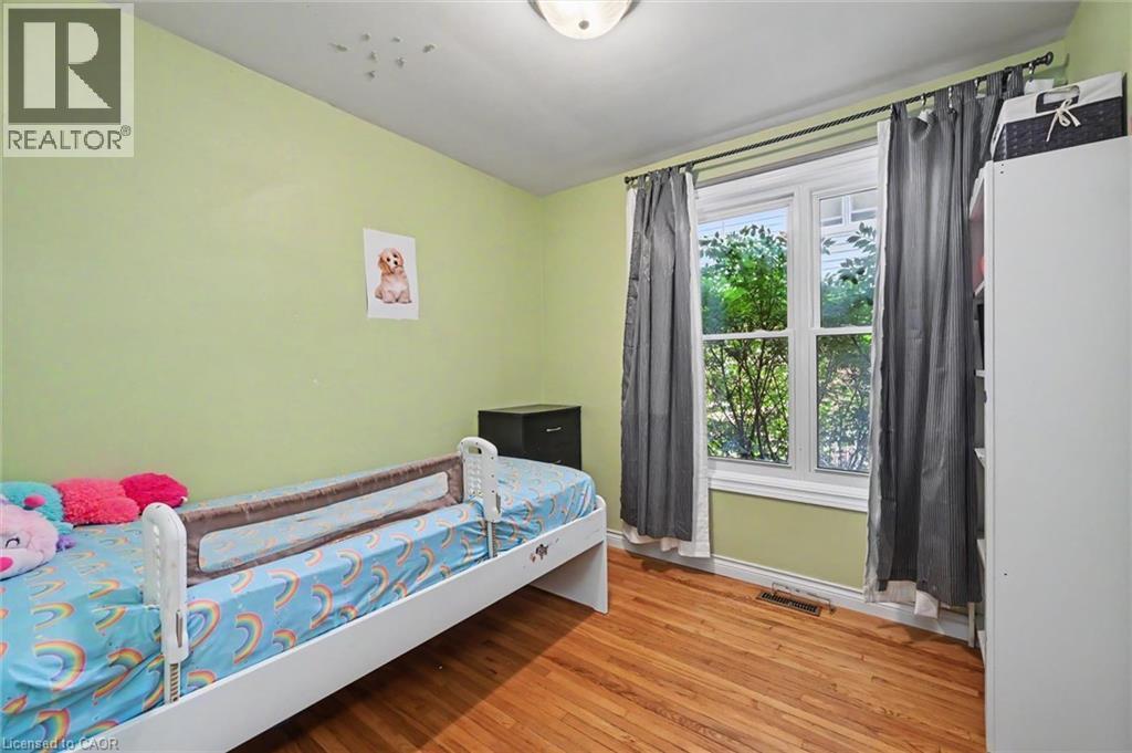 Bright room featuring wood-finish flooring, a double-hung window, and a flush mount ceiling light - 56 Everton Place, Hamilton, ON