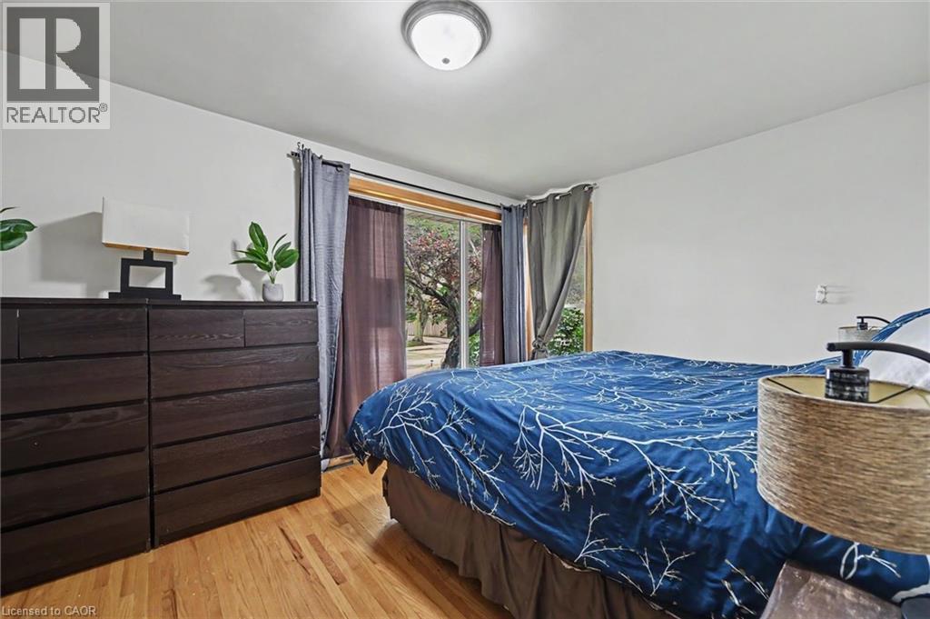 Light wood-finish flooring complements white walls and a ceiling-mounted flush light fixture - 56 Everton Place, Hamilton, ON