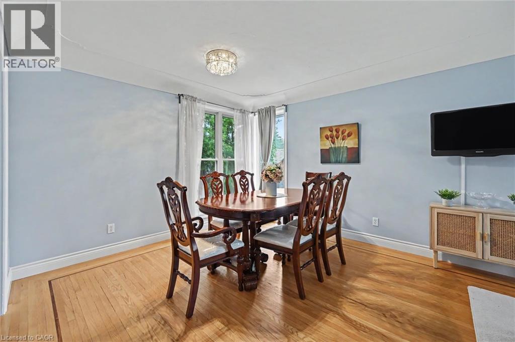 Hardwood flooring featuring an inlaid border, light blue wall paint, and white trim - 56 Everton Place, Hamilton, ON