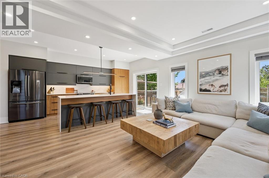 Open-concept living area featuring wood-finish flooring and recessed lighting - 63 Plymouth Road, Kitchener, ON