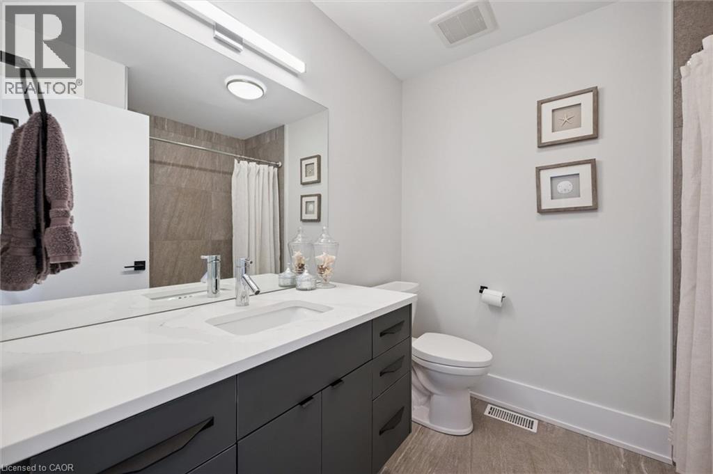 Bathroom featuring a spacious vanity with a white countertop and dark cabinetry - 63 Plymouth Road, Kitchener, ON