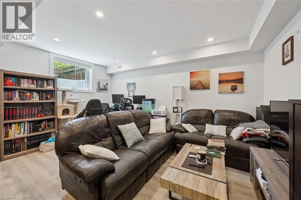 Recreation room featuring recessed lighting, wood-finish flooring, a window, and painted walls - 63 Plymouth Road, Kitchener, ON