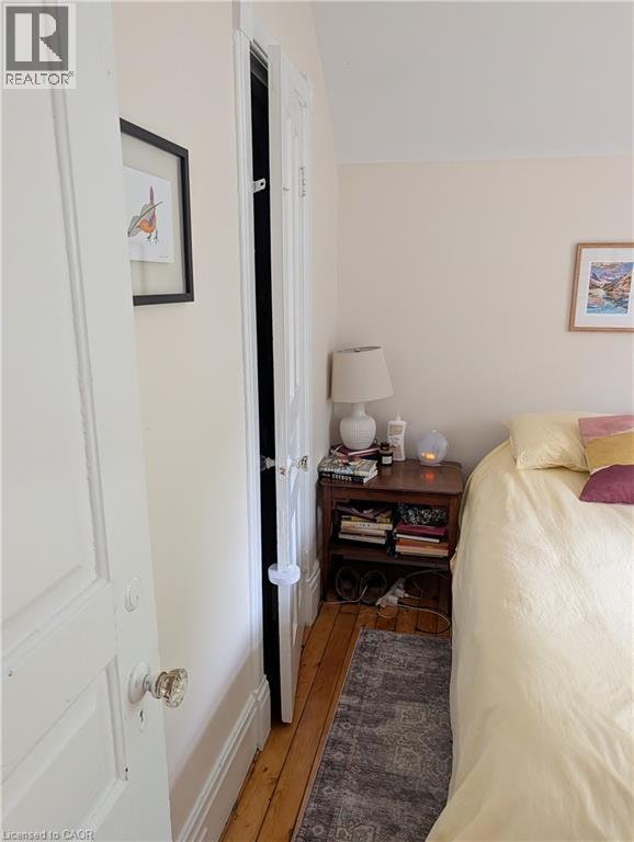 Light-toned walls with painted trim, wood-finish flooring, and area rug - 15 Martin Street, Kitchener, ON
