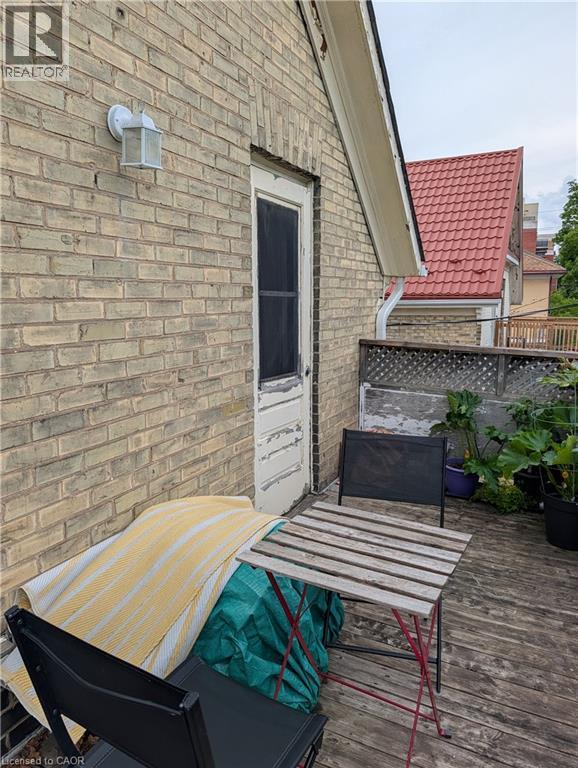 Outdoor wood-finish decking with a brick wall exterior - 15 Martin Street, Kitchener, ON