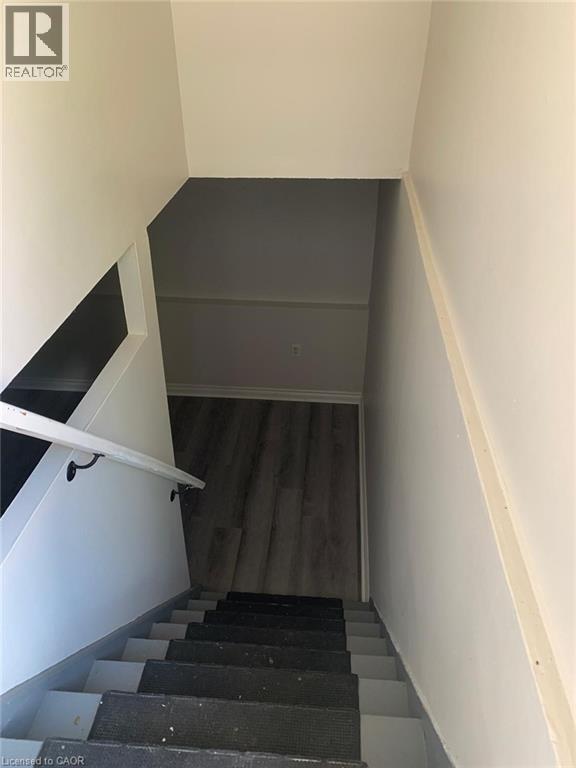 Staircase featuring a white handrail with black brackets, carpeted treads, and light gray risers - 58 Farrier Drive Unit# Basement, Kitchener, ON - Indoor Photo Showing Other Room