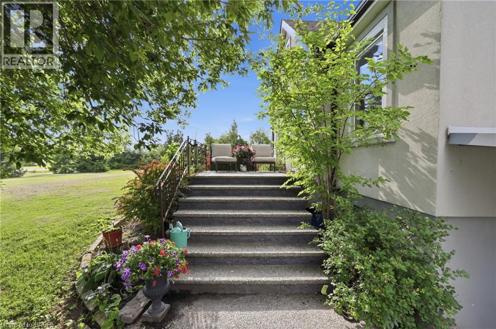 Exterior staircase with a wrought iron railing, leading to a raised porch - 97 Smith Road, Hamilton, ON