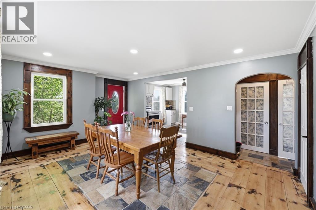 Spacious room featuring wide plank wood flooring and a central slate tile inlay - 97 Smith Road, Hamilton, ON