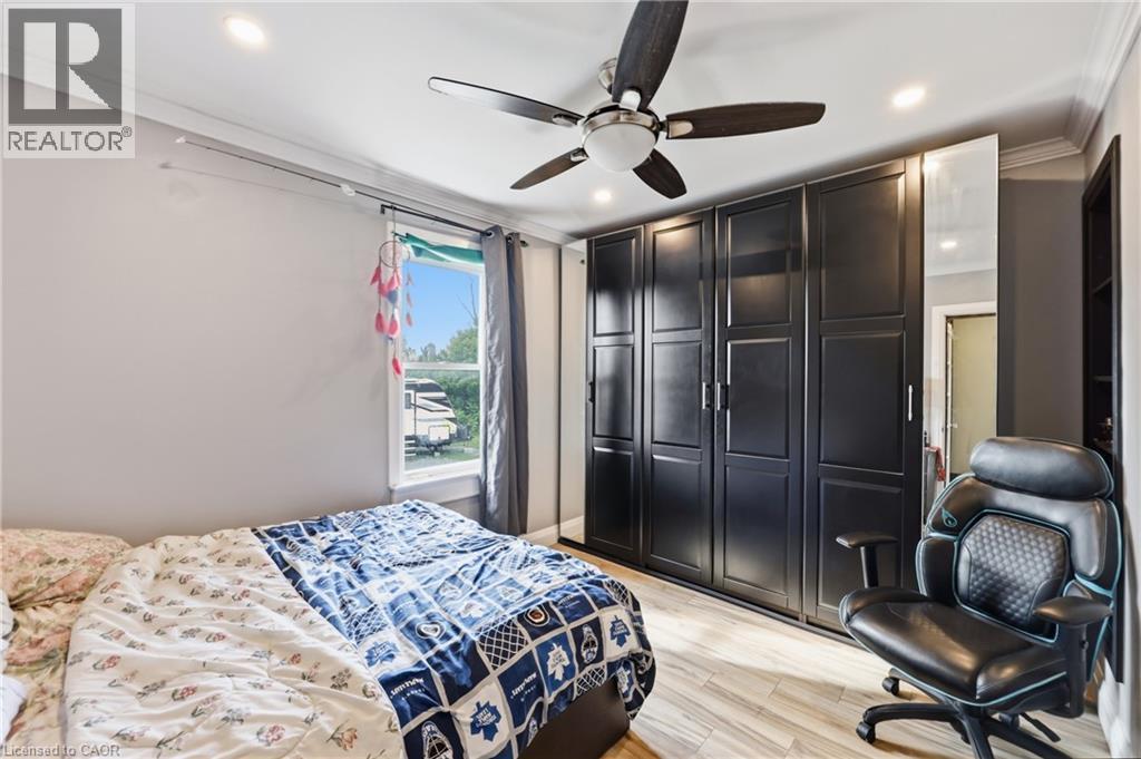 Recessed lighting and a ceiling fan illuminate this space featuring crown molding and wood-finish flooring - 97 Smith Road, Hamilton, ON
