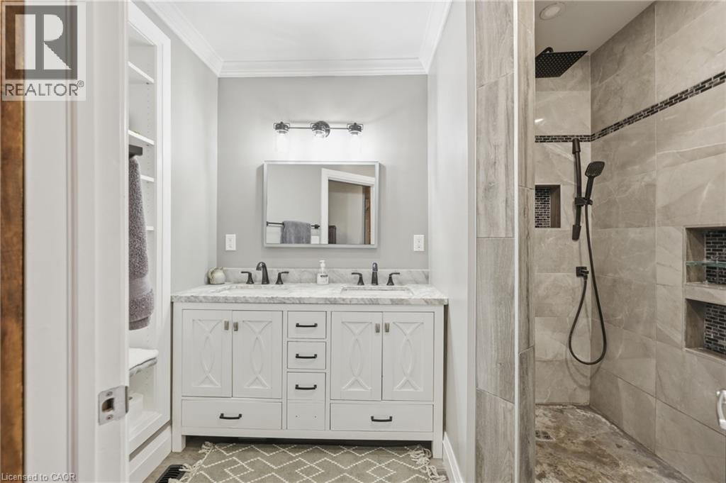 Dual vanity with white cabinetry and dark hardware, set against a light gray wall - 97 Smith Road, Hamilton, ON