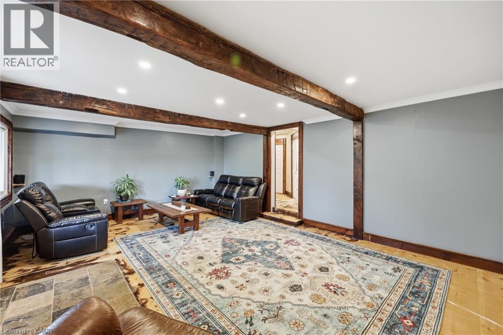 Exposed wood beams and columns define this living space featuring recessed lighting, light wood-finish flooring, and a window - 97 Smith Road, Hamilton, ON