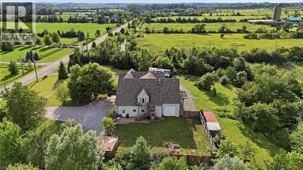 Gable roof structure with a dormer window, surrounded by green lawns and mature trees - 97 Smith Road, Hamilton, ON