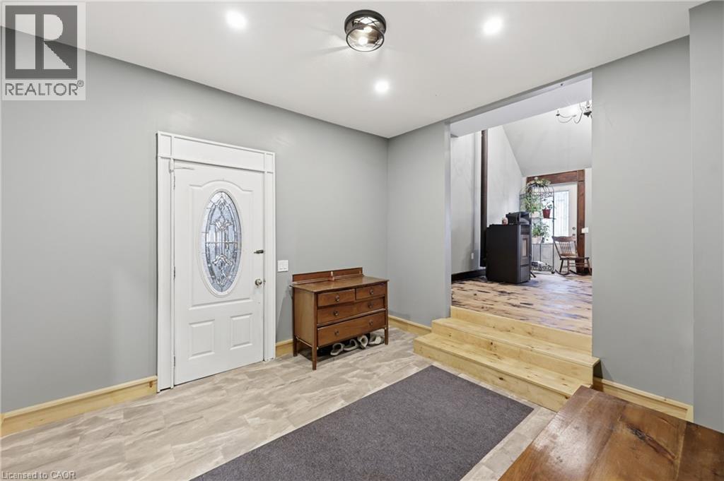 Entryway featuring a decorative glass-paneled door, recessed lighting, and a modern flush-mount light fixture - 97 Smith Road, Hamilton, ON