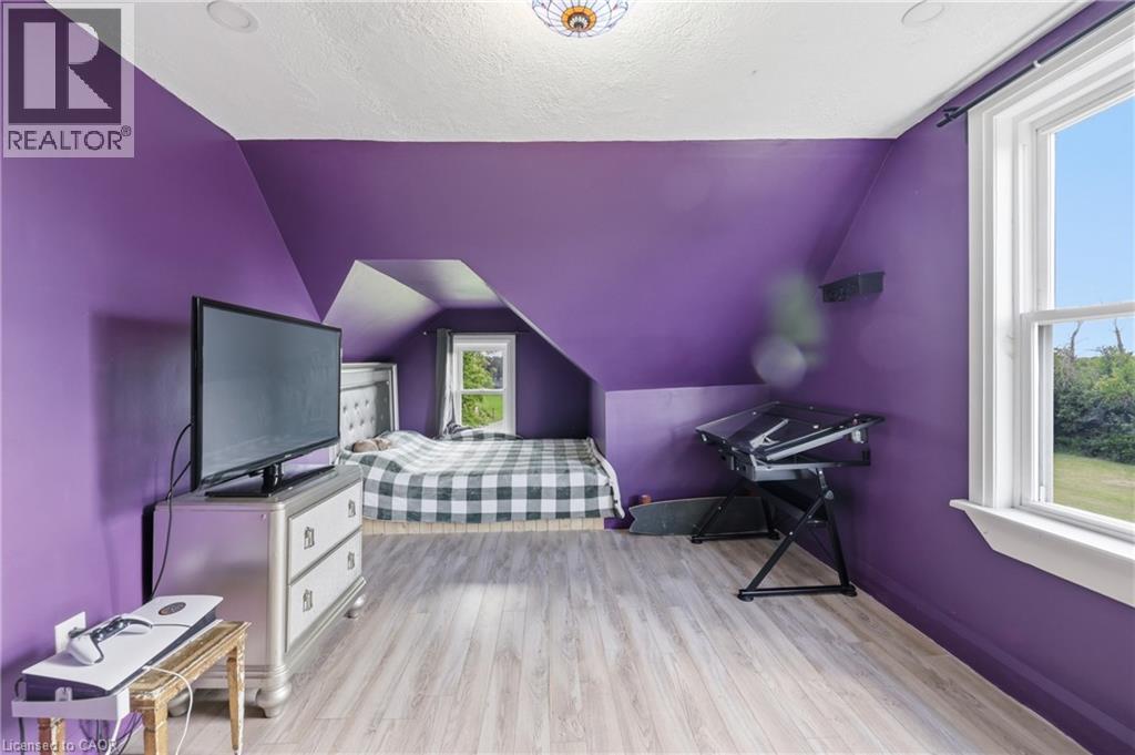 Room featuring sloped ceilings, light wood-finish flooring, recessed lighting, and a double-hung window - 97 Smith Road, Hamilton, ON