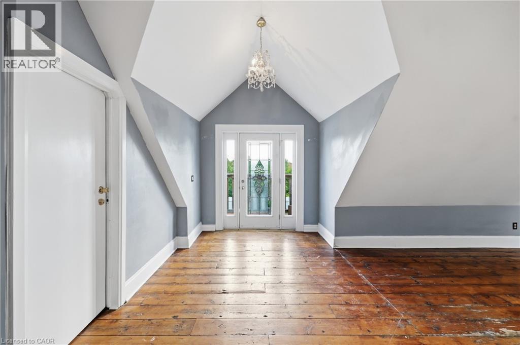 Room featuring rich wood-finish flooring and a distinctive vaulted ceiling - 97 Smith Road, Hamilton, ON