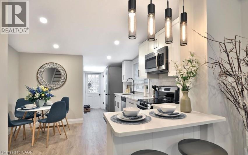 Open-concept kitchen and dining area featuring light wood-finish flooring - 33 Hawthorne Avenue, Hamilton, ON