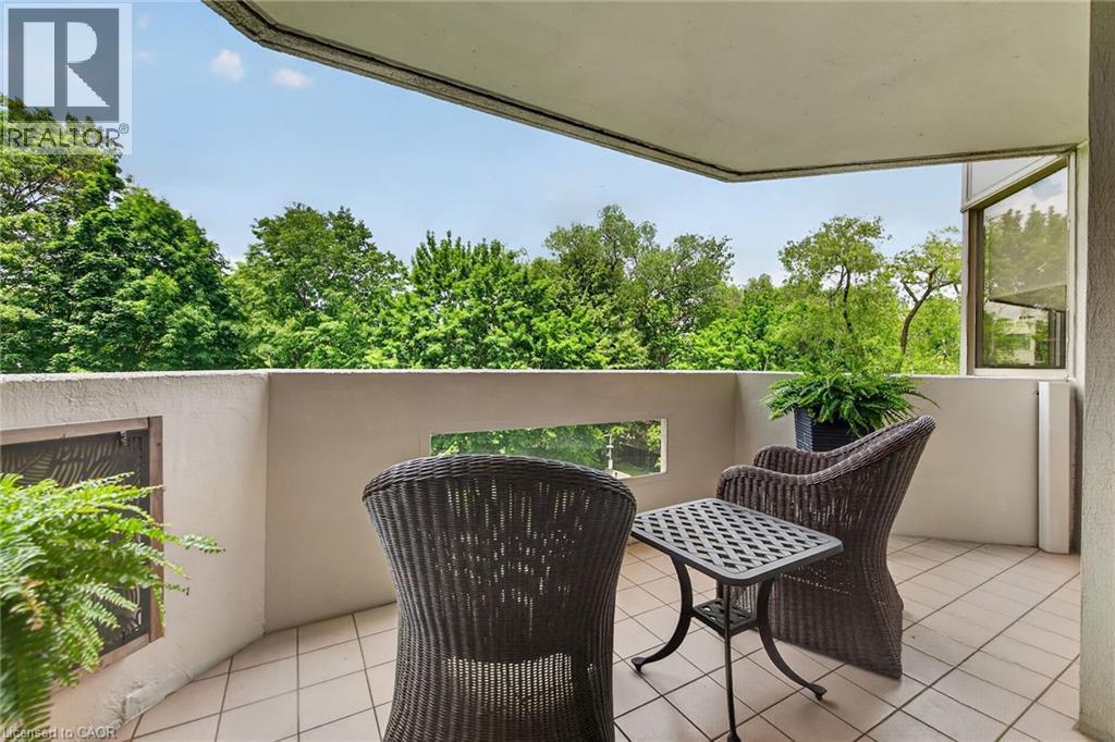 Outdoor balcony featuring light-toned tile flooring and a solid perimeter wall - 1237 North Shore Boulevard Unit# 405, Burlington, ON - Outdoor With Exterior