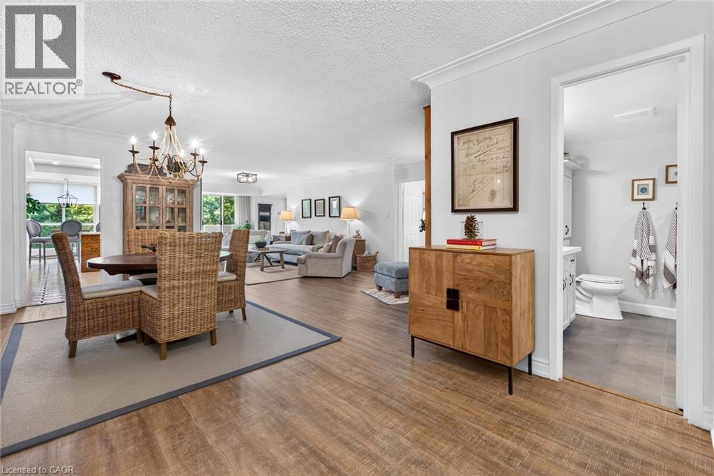 Open-concept interior featuring wood-finish flooring, recessed lighting, crown molding, and a chandelier - 1237 North Shore Boulevard Unit# 405, Burlington, ON - Indoor