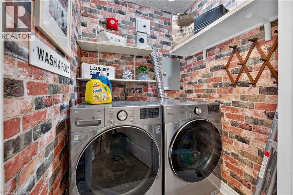 Dedicated laundry area featuring modern front-loading washer and dryer units - 1237 North Shore Boulevard Unit# 405, Burlington, ON - Indoor Photo Showing Laundry Room