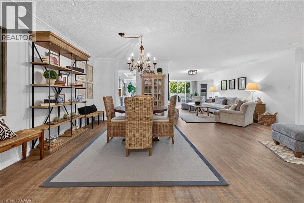Expansive open-concept living area featuring wood-finish flooring, recessed lighting, and crown molding - 1237 North Shore Boulevard Unit# 405, Burlington, ON - Indoor Photo Showing Living Room