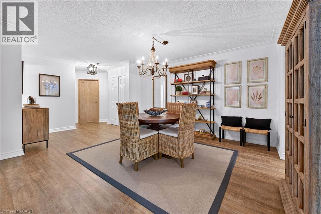 Open dining area featuring wood-finish flooring and crown molding - 1237 North Shore Boulevard Unit# 405, Burlington, ON - Indoor