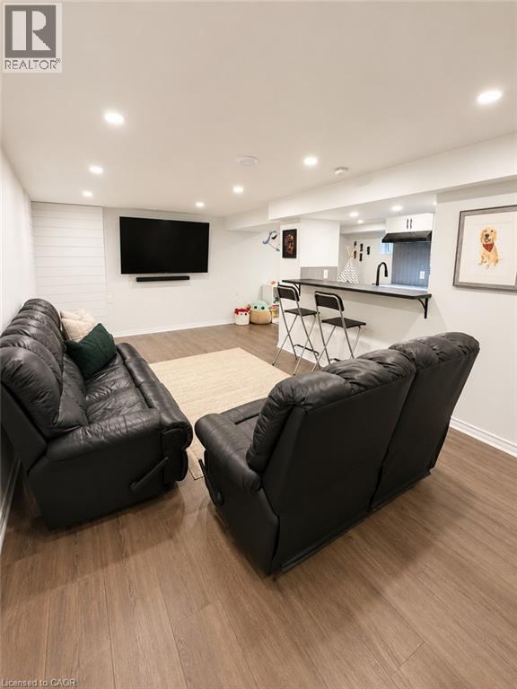 Finished lower level featuring recessed lighting, wood-finish flooring, and a contemporary wet bar - 355 East 36Th Street, Hamilton, ON