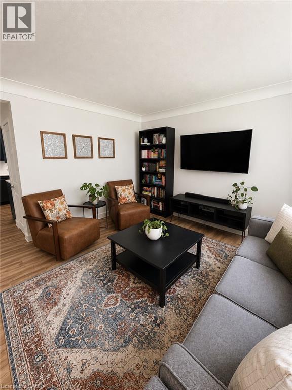Living area featuring wood-finish flooring, light-colored walls, and crown molding - 355 East 36Th Street, Hamilton, ON
