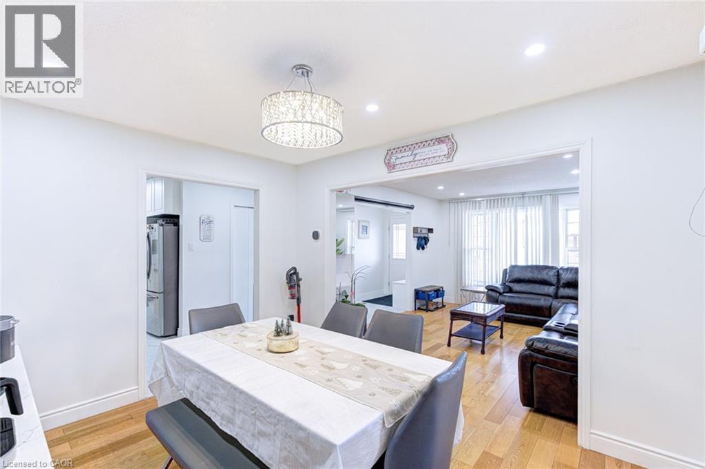 Dining area featuring wood-finish flooring, recessed lighting, and a decorative drum chandelier - 214 Merrilee Crescent, Hamilton, ON