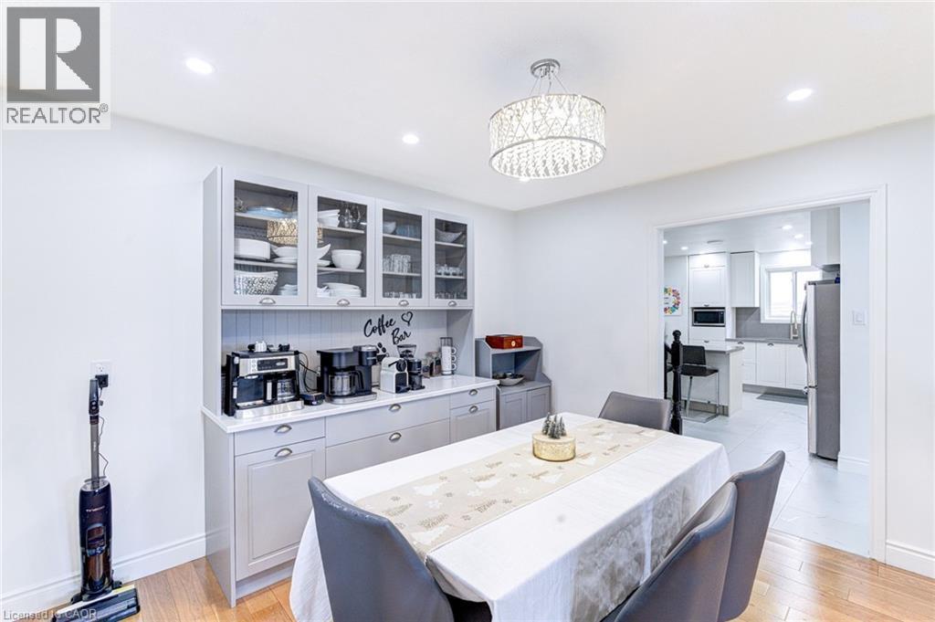 Dining area featuring a coffee bar with upper glass-front cabinetry, a crystal chandelier, recessed lighting, and wood-finish flooring - 214 Merrilee Crescent, Hamilton, ON