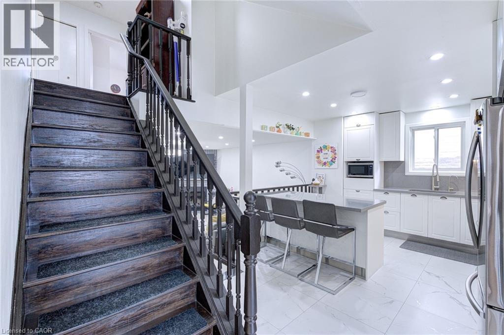 Dark wood staircase with carpeted treads and classic balusters - 214 Merrilee Crescent, Hamilton, ON