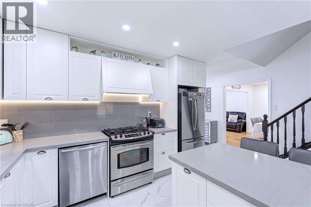 Well-appointed kitchen featuring white cabinetry, light gray countertops, and stainless steel appliances - 214 Merrilee Crescent, Hamilton, ON