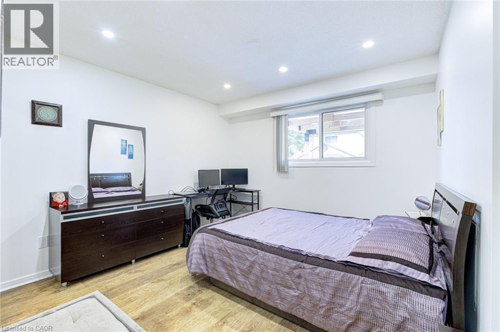 Room featuring wood-finish flooring, recessed lighting, and a window with a roller blind - 214 Merrilee Crescent, Hamilton, ON