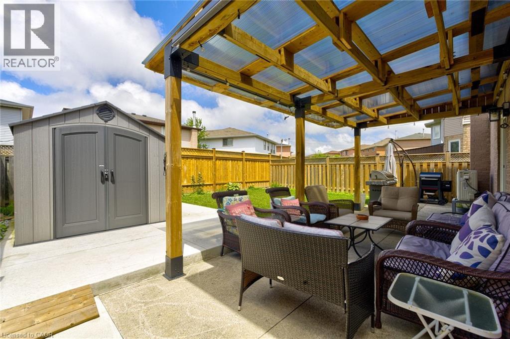 Spacious concrete patio featuring a wood pergola with a translucent roof - 214 Merrilee Crescent, Hamilton, ON