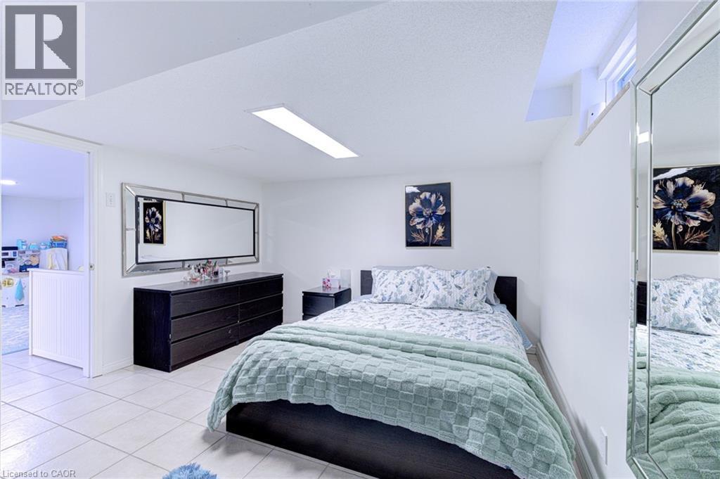 Bedroom featuring neutral wall paint, tile flooring, and a recessed window - 214 Merrilee Crescent, Hamilton, ON