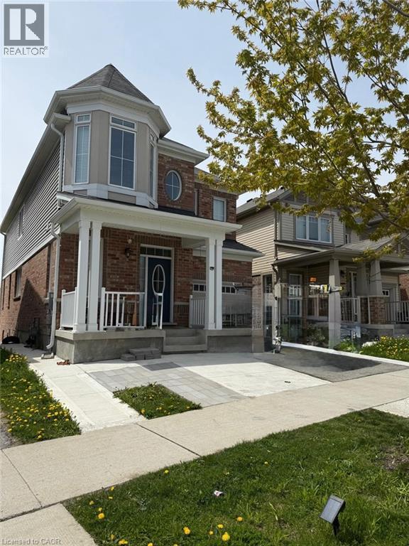 Brick and siding exterior featuring a prominent turret with a bay window and a round accent window - 63 Ridge Road Unit# Upper, Cambridge, ON