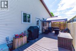 Expansive outdoor deck area featuring composite decking, privacy fencing, and a covered patio structure - 