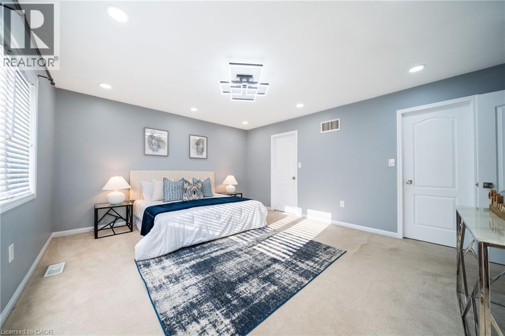 Spacious room featuring neutral carpeting, recessed lighting, and a modern ceiling fixture - 151 Baldwin Drive, Cambridge, ON