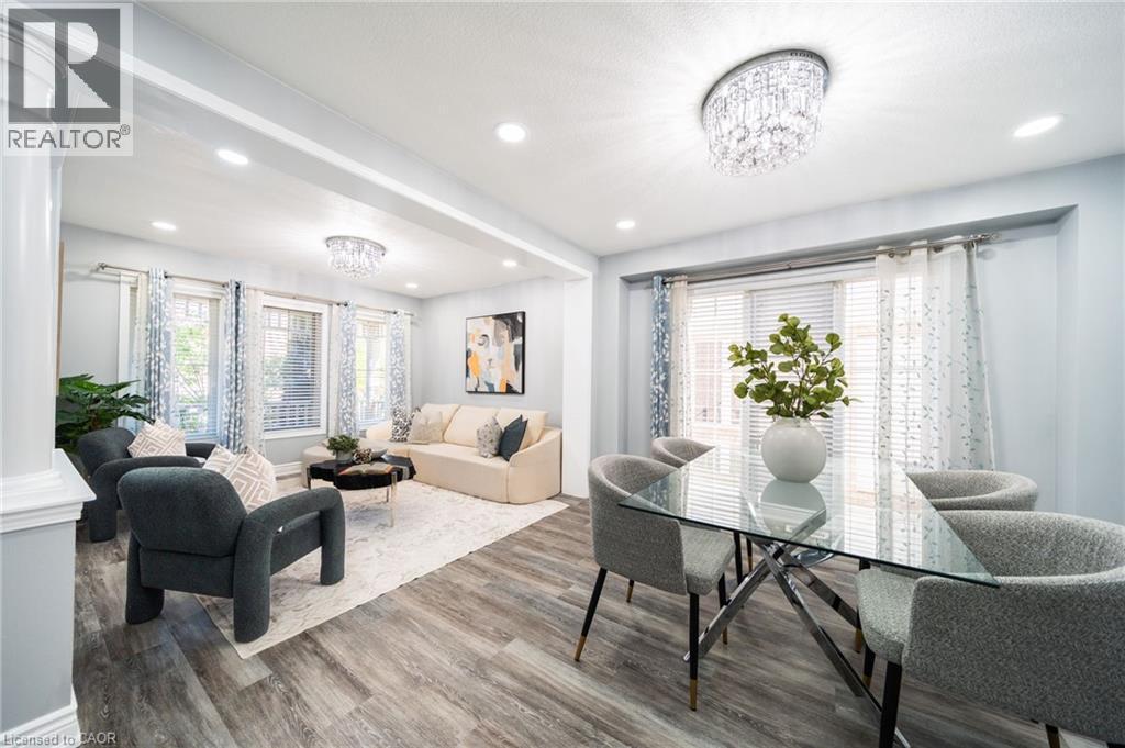 Open-concept living and dining areas featuring wood-finish flooring, recessed lighting, and a crystal chandelier - 151 Baldwin Drive, Cambridge, ON - Indoor