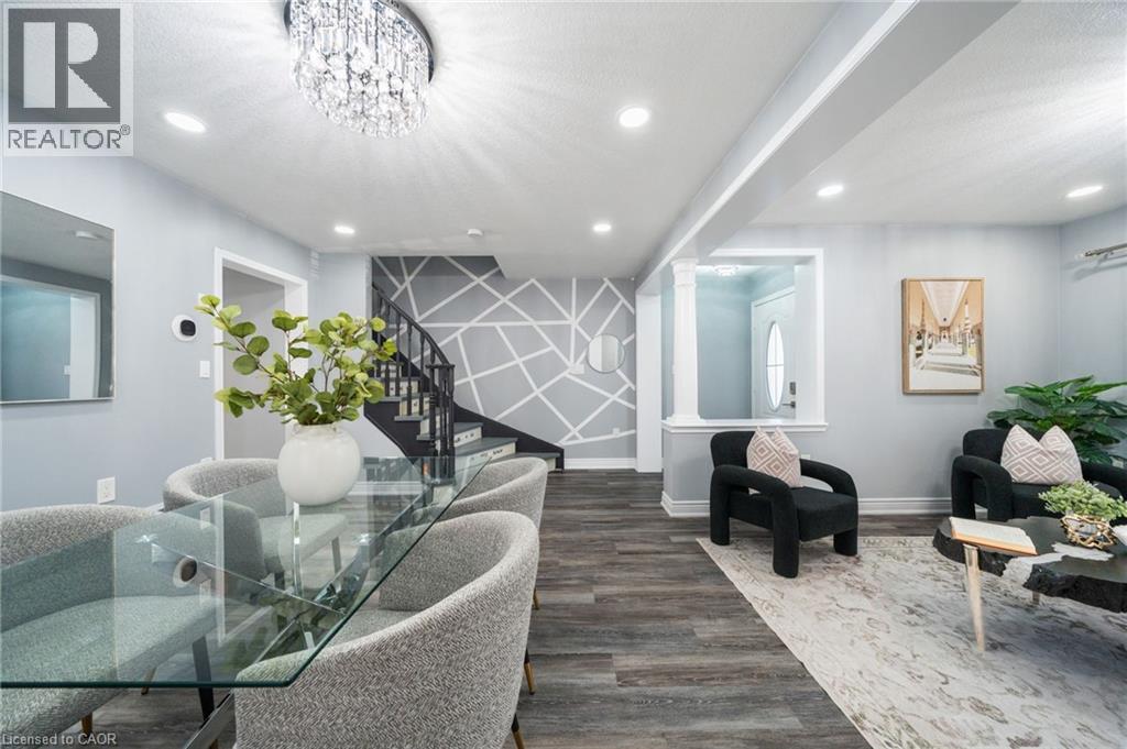 Open-concept main level featuring wood-finish flooring, recessed lighting, and a contemporary crystal chandelier - 151 Baldwin Drive, Cambridge, ON - Indoor