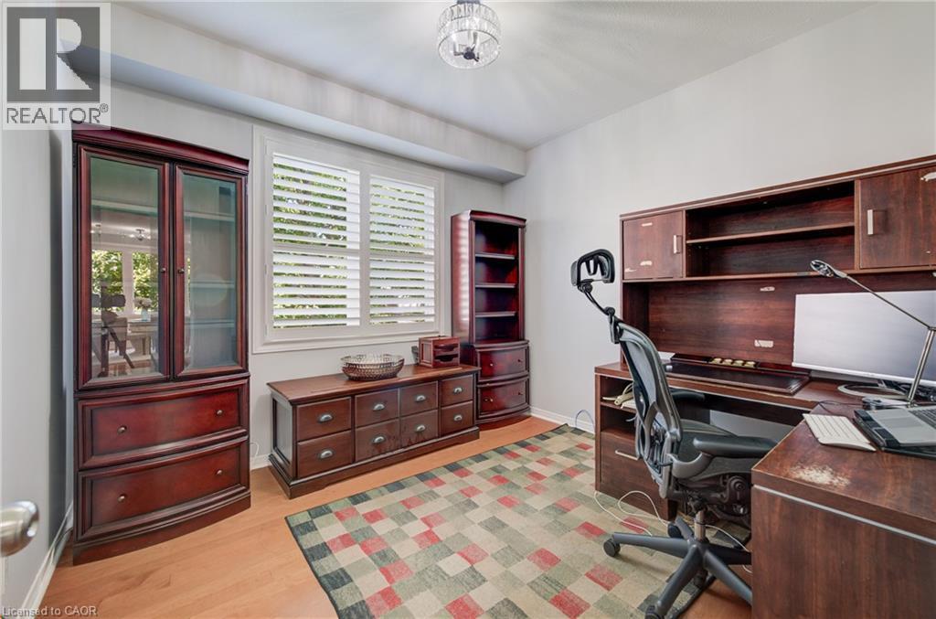 Versatile room featuring wood-finish flooring, white walls, and a ceiling-mounted light fixture - 23 Buerkle Court, Kitchener, ON - Indoor Photo Showing Office